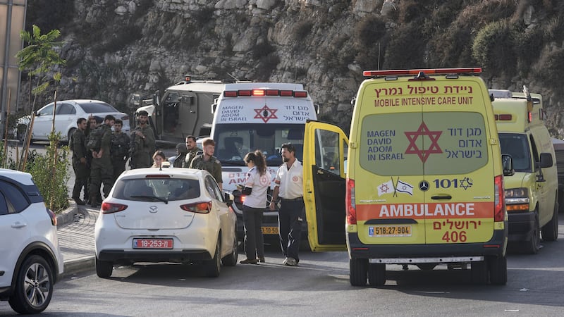 Israeli soldiers and emergency personnel gather near ambulances following a shooting attack...