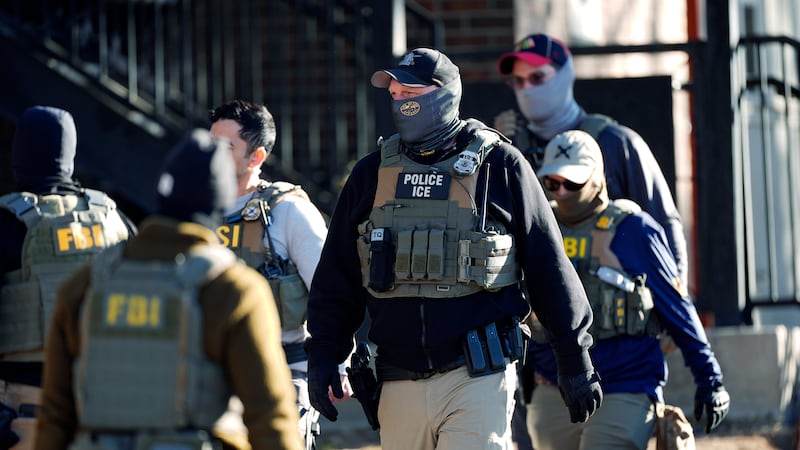 Law officials spread out through an apartment complex during a raid Wednesday, Feb. 5, 2025,...