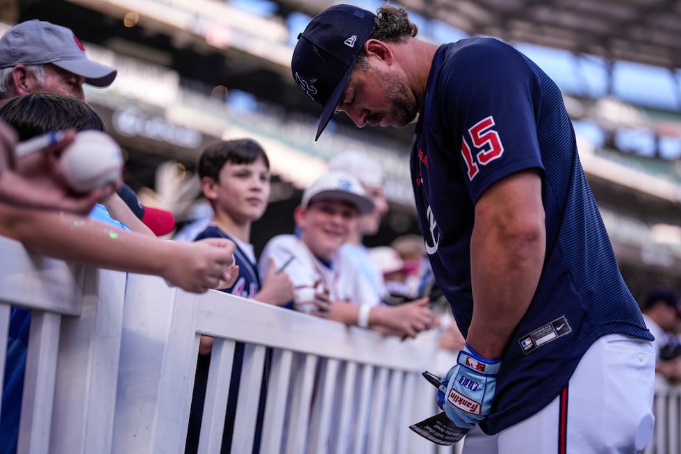 Atlanta Braves second baseman Kyle Farmer signs autographs before a baseball game between the...